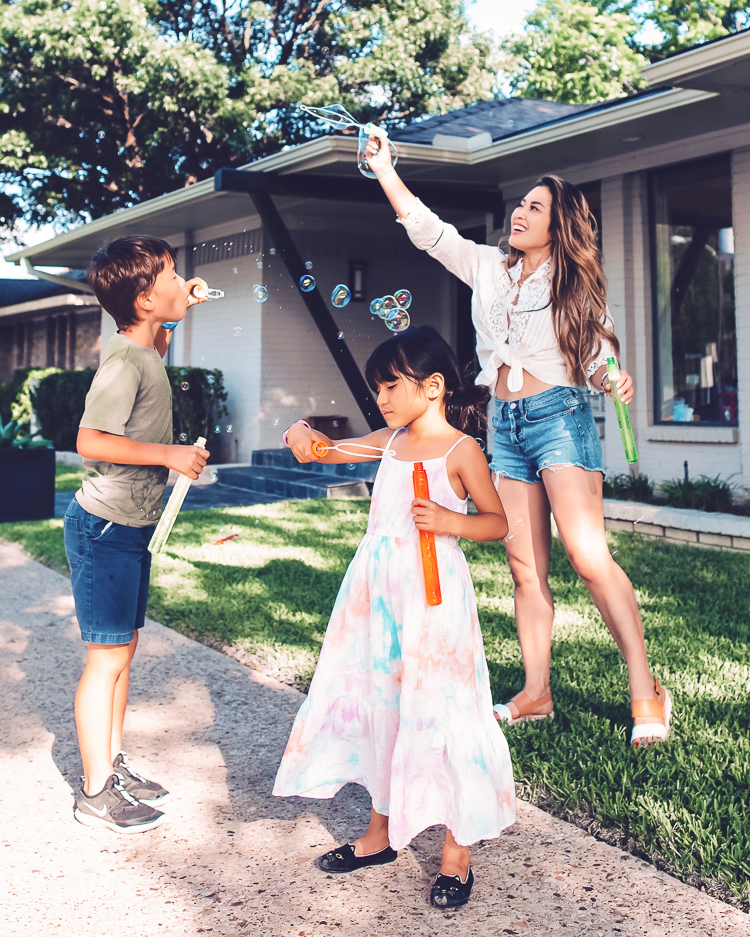 cute & little | dallas mom family travel blog | walmart pickup and delivery | summer kids' outdoor activities | Fun Summer Activities by popular Dallas lifestyle blog, Cute and Little: image of a mom and her young son and daughter playing with bubbles outside. 