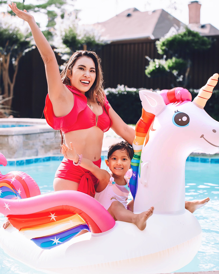 cute & little | dallas mom family travel blog | walmart plus review | backyard pool day must-haves | Pool Day by popular Dallas lifestyle blog, Cute and Little: image of a woman wearing a red bikini and sitting in a unicorn pool float in a swimming pool with her daughter.