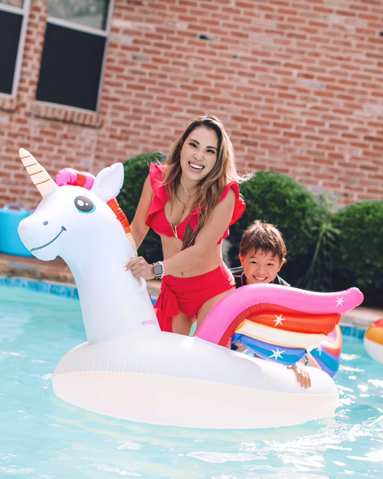 cute & little | dallas mom family travel blog | walmart plus review | backyard pool day must-haves | Pool Day by popular Dallas lifestyle blog, Cute and Little: image of a a woman wearing a red bikini and sitting in a unicorn pool float in a swimming pool with her son. 