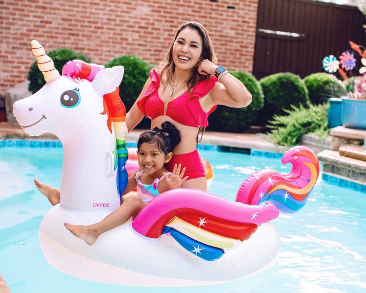 cute & little | dallas mom family travel blog | walmart plus review | backyard pool day must-haves | Pool Day by popular Dallas lifestyle blog, Cute and Little: image of a woman wearing a red bikini and sitting in a unicorn pool float in a swimming pool with her young daughter. 