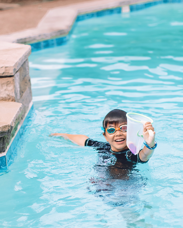 cute & little | dallas mom family travel blog | walmart plus review | backyard pool day must-haves | Pool Day by popular Dallas lifestyle blog, Cute and Little: image of a young boy standing in a swimming pool and wearing a pair of swim goggles. 