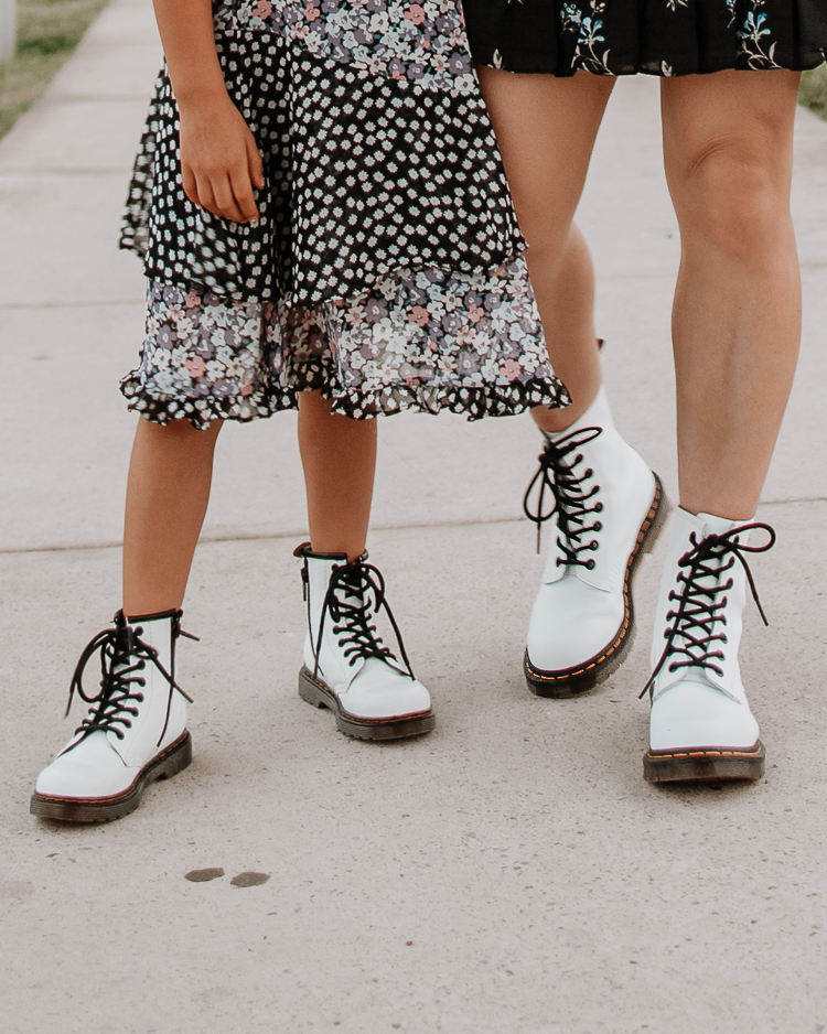 cute & little | dallas petite fashion mom blogger | twinning mom daughter white doc marten combat boots | fall outfit | Doc Martens Combat Boots by popular Dallas petite fashion blog, Cute and Little: image of a woman and her daughter standing together outside and wearing black floral print dresses with matching white Doc Martens combat boots. 